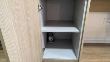 A wooden cabinet with a metal latch, a shelf, and a canister.