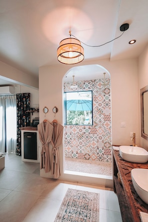 Une salle de bain avec un mur ornĂ© dâun motif, un lavabo, un miroir et un porte-peignoir suspendu.