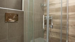 A bathroom with a glass-enclosed shower, a toilet, and a wall-mounted flush handle. - Sveti Stefan Panorama View Apartment (Sveti Stefan)