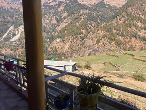 Ein Balkon mit Blick auf terrassenförmig angelegte Felder und ein Berg.