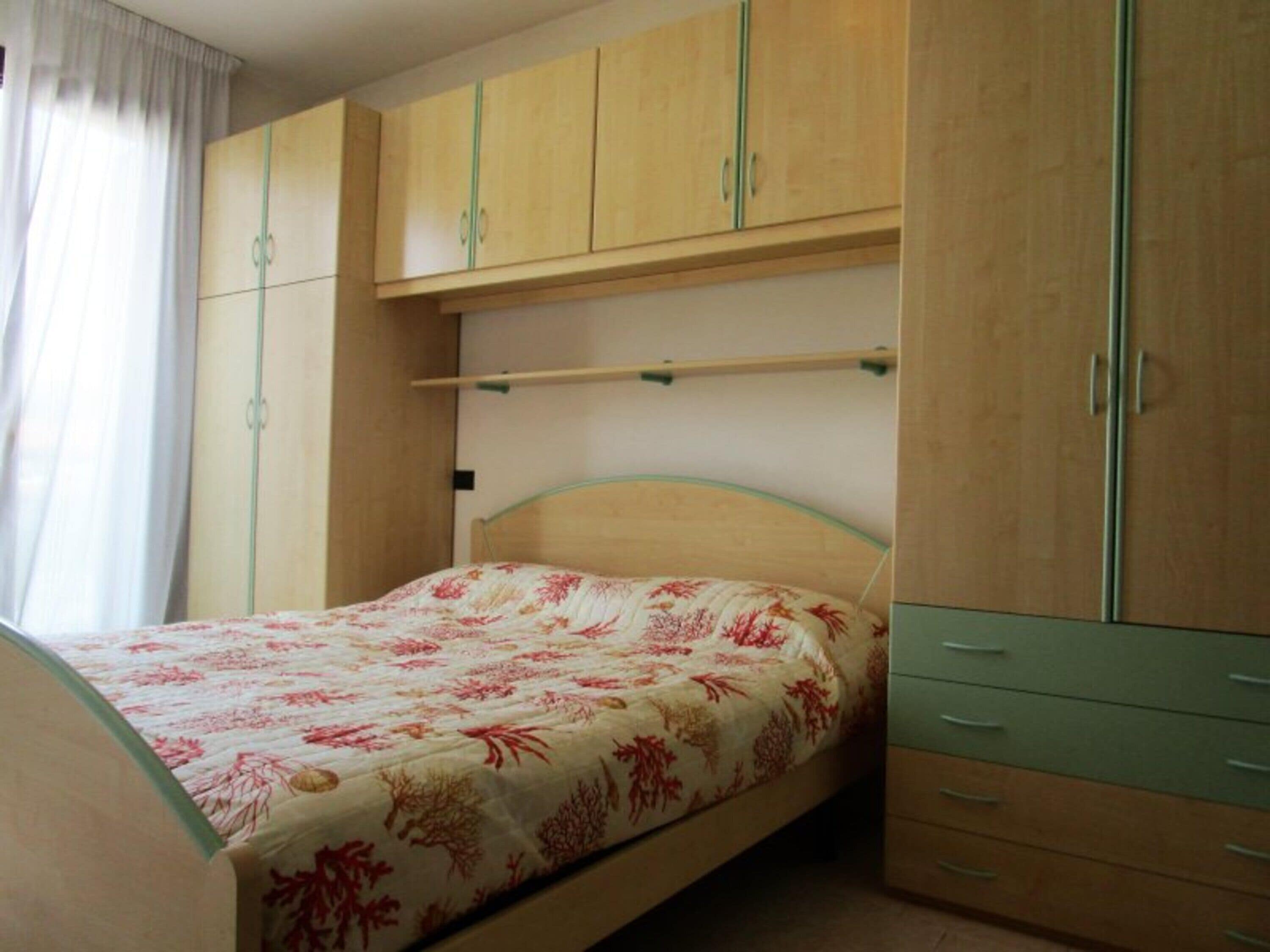 Une chambre à coucher avec un lit, une armoire en bois et un petit bureau.