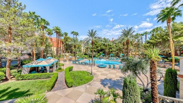 A resort with a swimming pool, palm trees, and a gazebo. - Entire Condo just a short walk from the Strip! (Las Vegas)