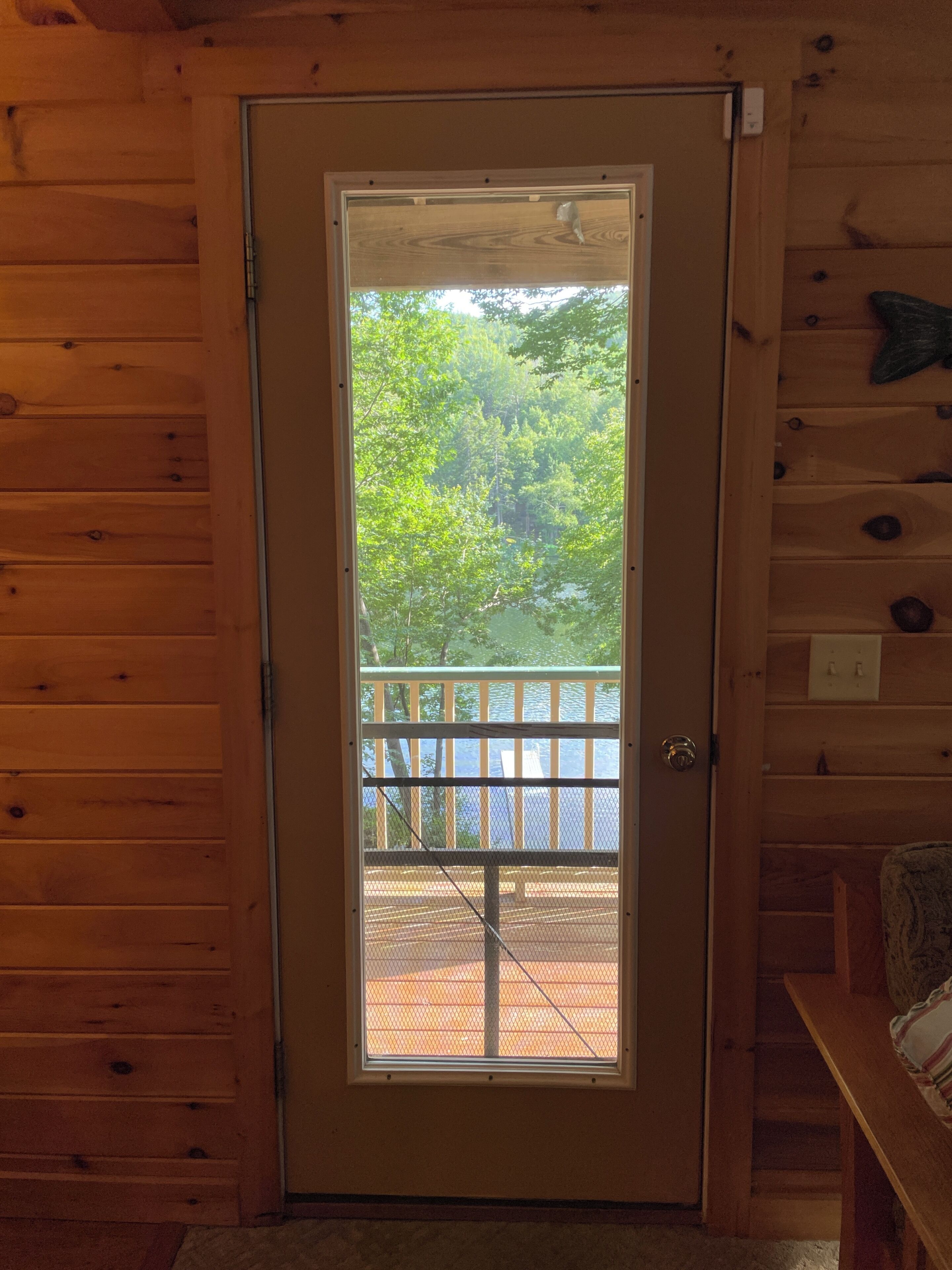 Une porte en bois donnant sur un balcon et un espace extérieur.