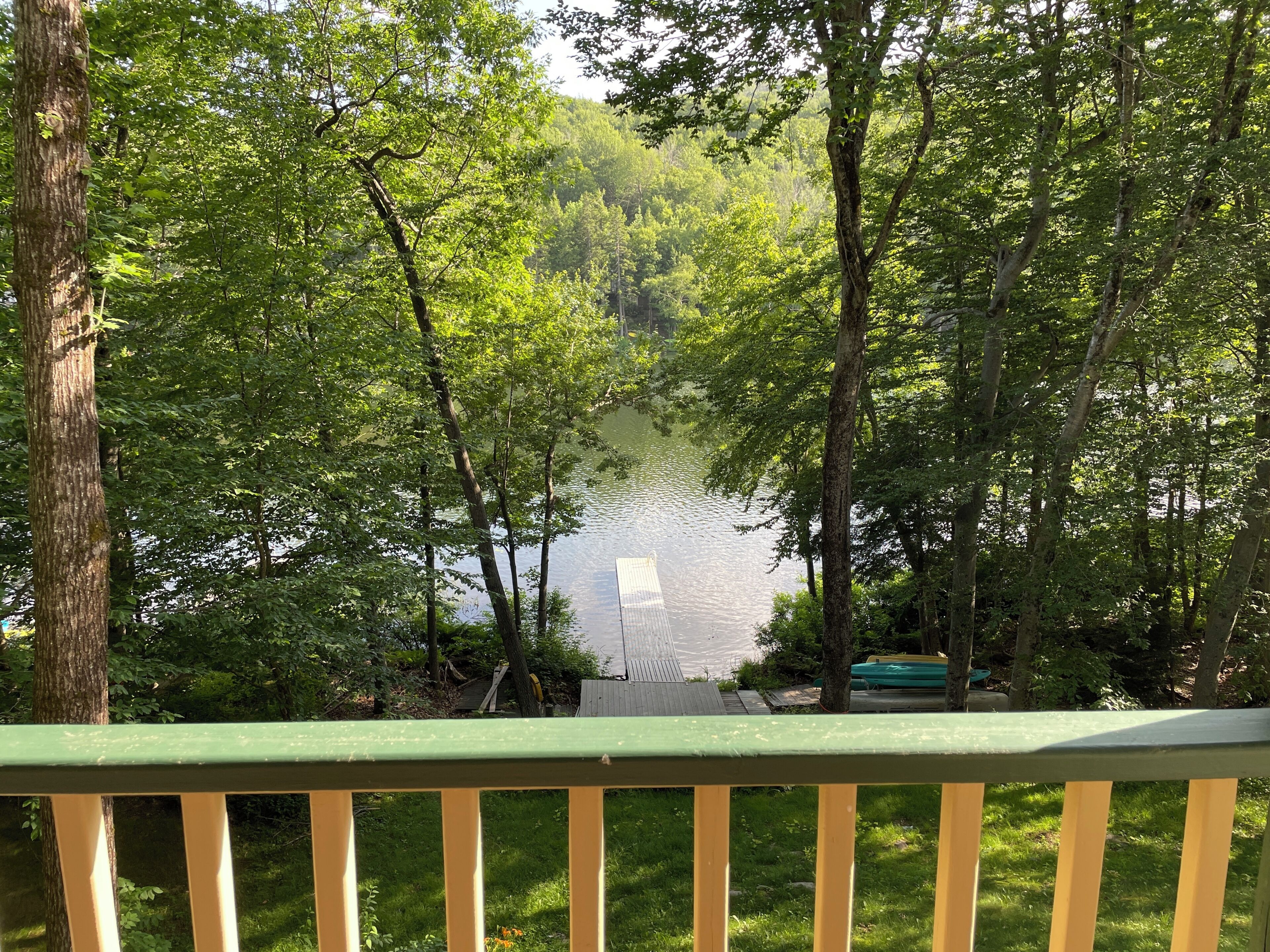 Une terrasse donnant sur un lac, entouré d’arbres.