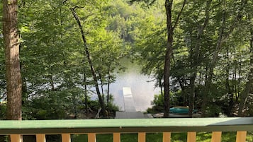 Une terrasse donnant sur un lac, entouré d’arbres.