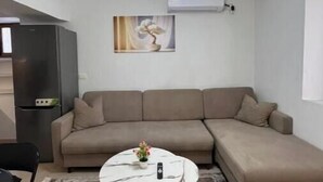 Ein modernes Wohnzimmer mit Ecksofa, rundem Couchtisch und einer besonderen Pendelleuchte.