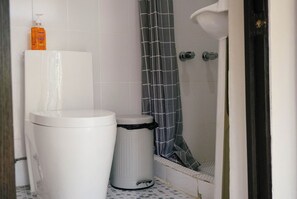 Deluxe tweepersoonskamer | Badkamer | Een douche, een haardroger, handdoeken, zeep