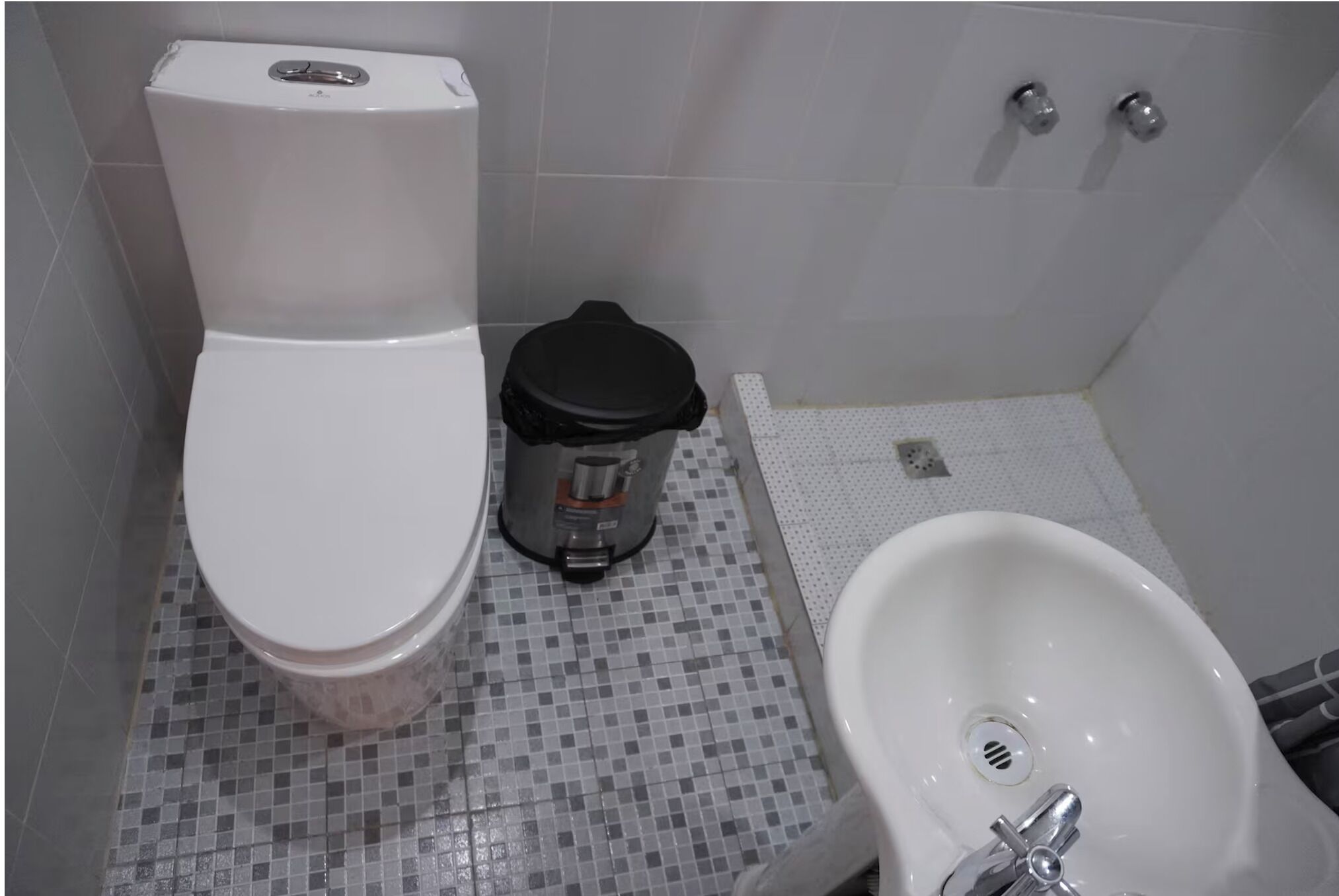 Un baño con inodoro, bidé y lavamanos.