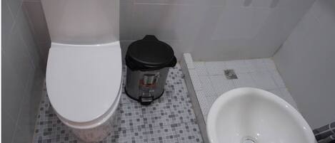 Un baño con inodoro, bidé y lavamanos.