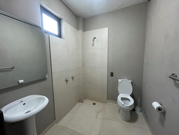 A small bathroom with a toilet, sink, and a window. - Villa del Carmen (San Gaspar)
