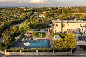 A modern villa with a swimming pool, outdoor seating, and a view of the surrounding landscape. - The Infinities - Premium Villa Alexandros (Kos)