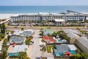 Ein Küstenhotel mit mehreren Gebäuden, einem Parkplatz und Blick auf den Strand.