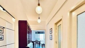 Un couloir avec un luminaire, une porte et une fenêtre.
