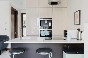 Eine moderne Küche mit Kochinsel, Edelstahlgeräten und einem eingebauten Backofen.