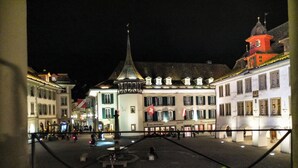 Una plaza con una fuente central, rodeada de edificios históricos de arquitectura tradicional europea.