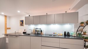 Una cocina moderna con gabinetes grises, una encimera negra y varios electrodomésticos.