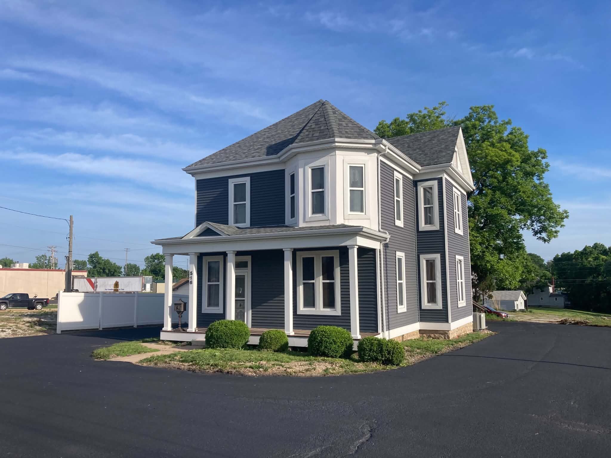 A two-story house with a gabled roof, a front porch, and a mailbox.