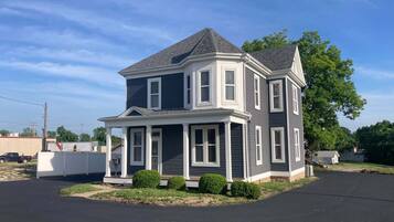 A two-story house with a gabled roof, a front porch, and a mailbox.