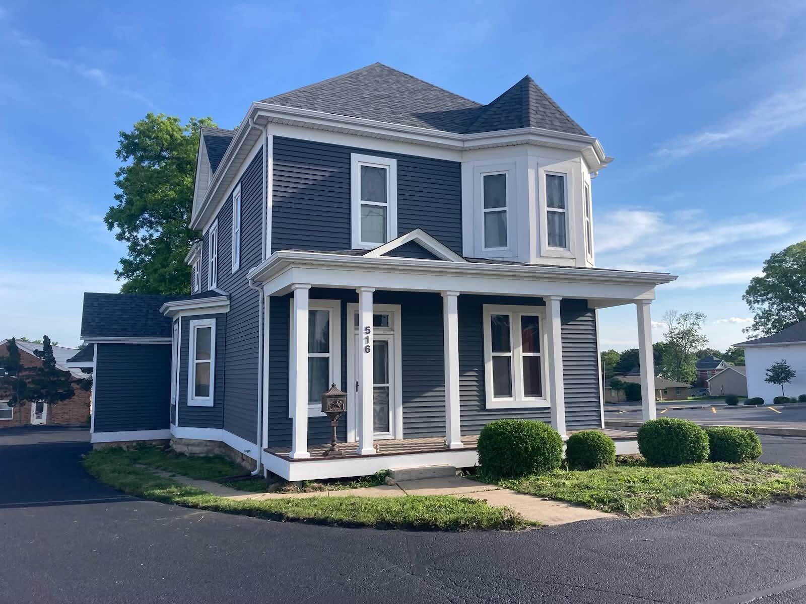 A two-story house with a front porch, a mailbox, and a number '516' on the door.