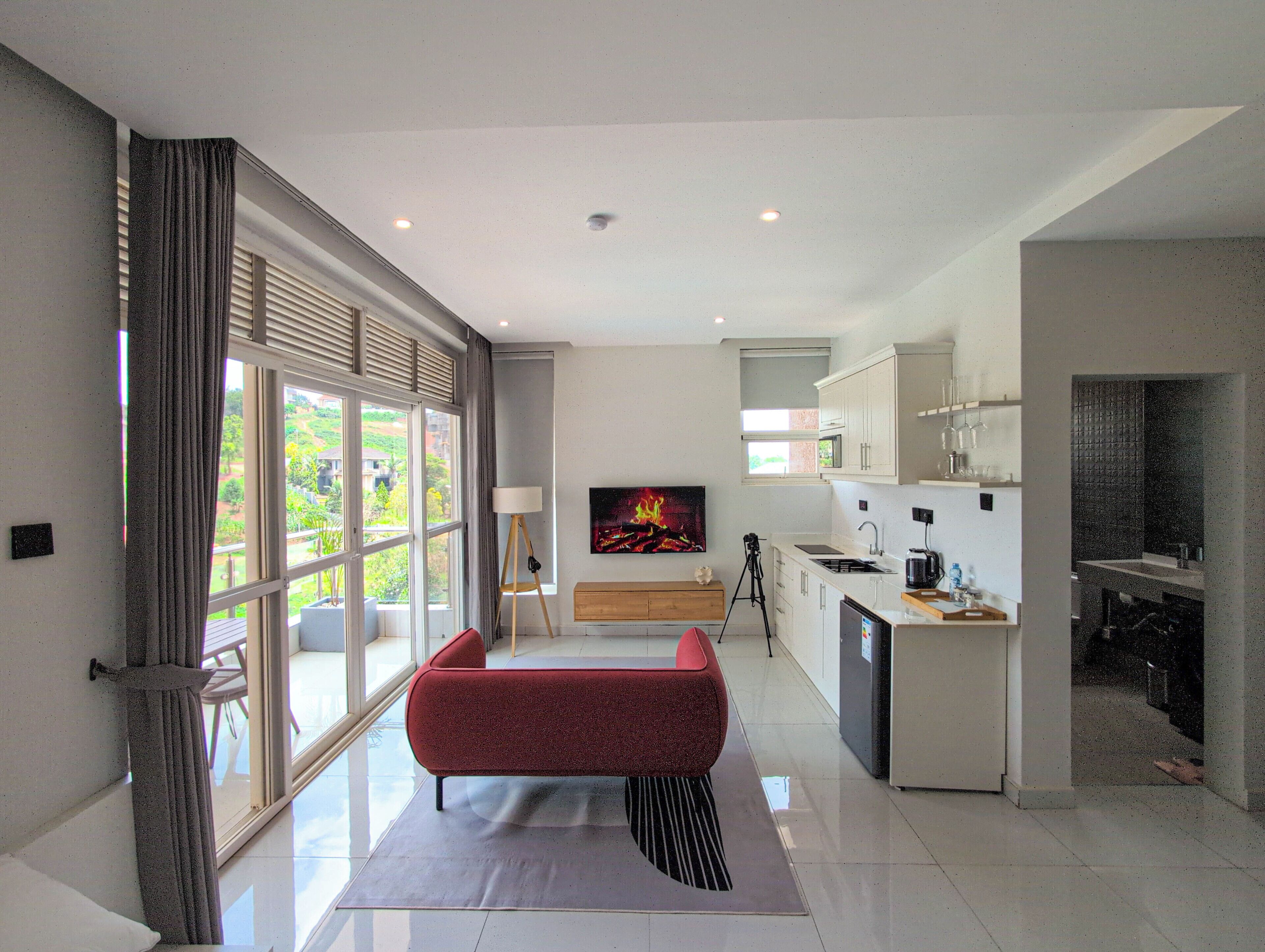 A modern kitchen with a built-in oven, a sink, and a countertop with a kettle.