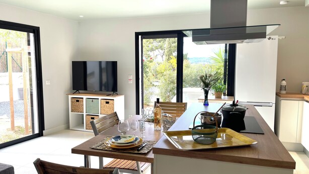 Uma cozinha moderna com área de refeições, TV e vista para o exterior.