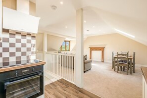 A spacious loft with a kitchen, dining area, and a fireplace. - Chestnut Cottage in Bix (Bix)