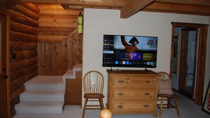 A wooden interior with a television mounted on the wall displaying a menu.