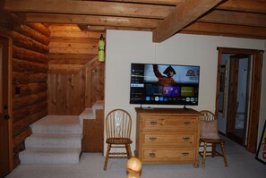 A wooden interior with a television mounted on the wall displaying a menu.
