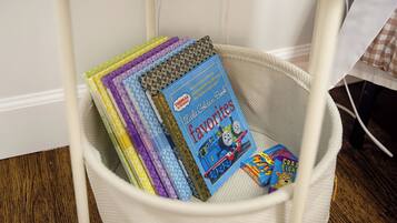 Un panier blanc contenant des livres, dont un livre de la série « Thomas et ses amis ».