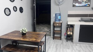 A kitchen with a dining table, a water dispenser, a fan, and a painting on the wall. - Apartment with Wi-Fi, A/C, and parking—near downtown and the boulevard (Chetumal)