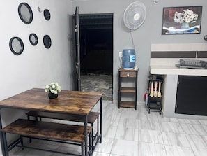 A kitchen with a dining table, a water dispenser, a fan, and a painting on the wall. - Apartment with Wi-Fi, A/C, and parking—near downtown and the boulevard (Chetumal)