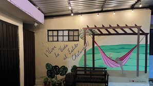 A room with a hammock, a bench, and a mural with text. - Apartment with Wi-Fi, A/C, and parking—near downtown and the boulevard (Chetumal)