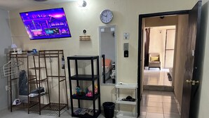 A hotel room with a TV, a clock, a mirror, and a door leading to another room. - Apartment with Wi-Fi, A/C, and parking—near downtown and the boulevard (Chetumal)
