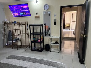 A hotel room with a TV, a clock, a mirror, and a door leading to another room. - Apartment with Wi-Fi, A/C, and parking—near downtown and the boulevard (Chetumal)
