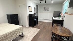 Een slaapkamer met een bed, een bureau en een stoel.