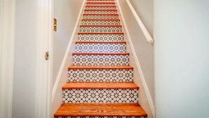 Eine Treppe mit gemusterten Fliesen und Holzhäuschen.