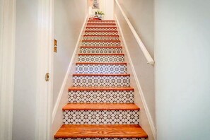 Eine Treppe mit gemusterten Fliesen und Holzhäuschen.