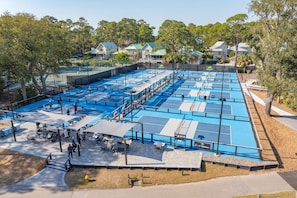 A large outdoor swimming pool with multiple lanes, surrounded by trees and residential buildings. - Sea Pines Escape with Private Pool (Hilton Head Island)