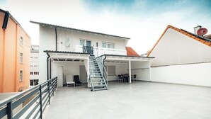A building with a covered patio, a staircase, and a satellite dish. - Hotel Three Corners (Grenzach-Wyhlen)