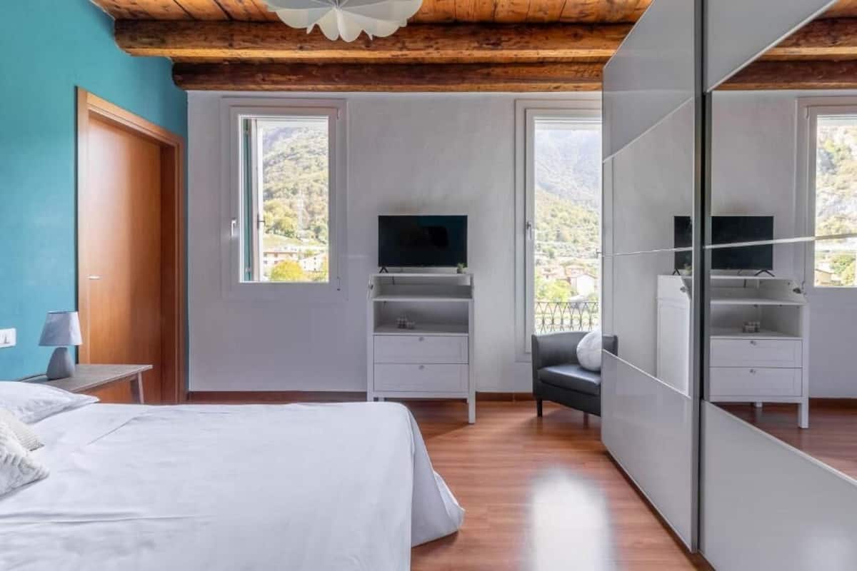 Un dormitorio con cama, televisor, escritorio y silla.