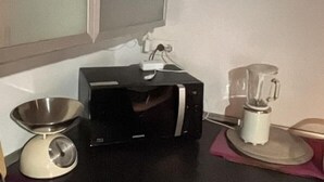 A kitchen with a microwave, a blender, and a weighing scale. - Rabi Rooms (Valbrenta)