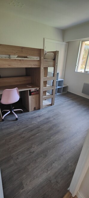A room with a bunk bed, a desk with a chair, and a window. - Fully renovated 3-room apartment, quiet and close to downtown (Vence)