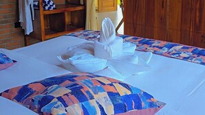 Habitación de hotel con una cama, un armario de madera, un perchero y un cartel en la pared que dice 'REGLAS DEL INODO'.