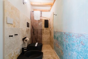 Un bagno con doccia, WC e lavandino.