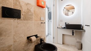 Ein modernes Badezimmer mit Toilette, Waschbecken und Spiegel.