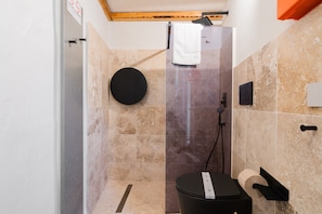 Ein Badezimmer mit Dusche, Toilette und Handtuchhalter.