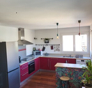 A kitchen with a stainless steel range hood, a microwave, a sink, and a dishwasher. - Bright apartment in Toulon (Toulon)