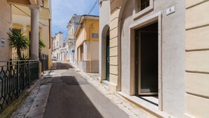 A narrow street with buildings on either side, a clear sky, and a sign indicating a hotel. - Suite 'Luxury Rooms - Erika' with Wi-Fi and Air Conditioning (Alezio)