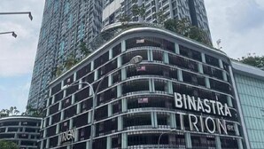 Un immeuble de grande hauteur sur lequel on peut voir une enseigne bien visible indiquant « BINASTRA TRION ».