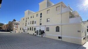Un edificio de varios pisos con fachada plana, ventanas amplias y una entrada central.